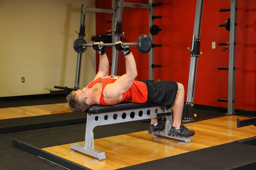 Pullover con barra y brazos flexionados, final