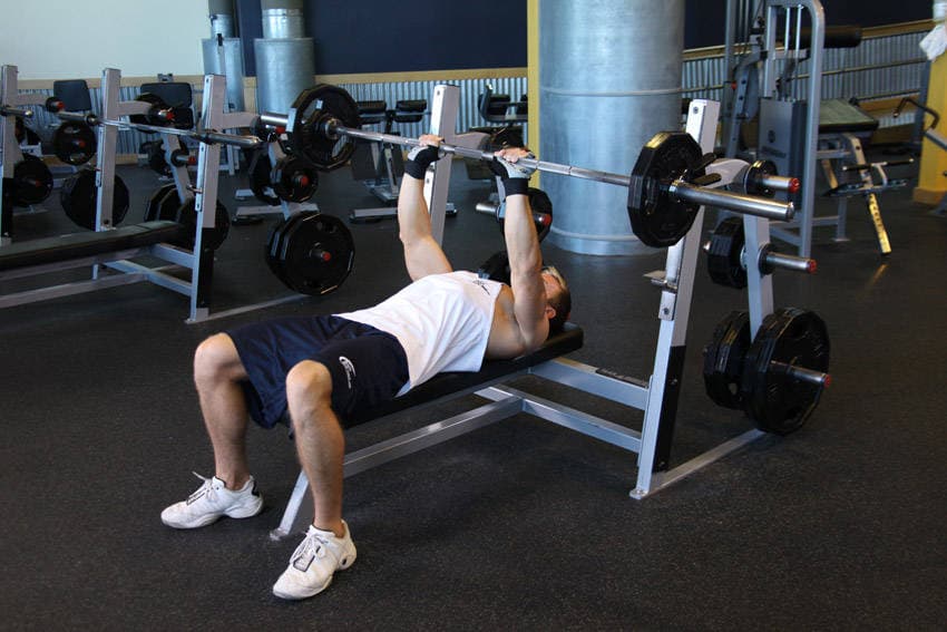 Press de banca con barra, agarre cerrado, final