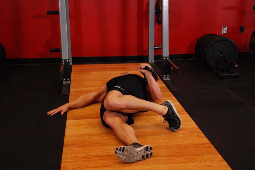 Press en el suelo a una mano con kettlebell y recorrido ampliado, inicio