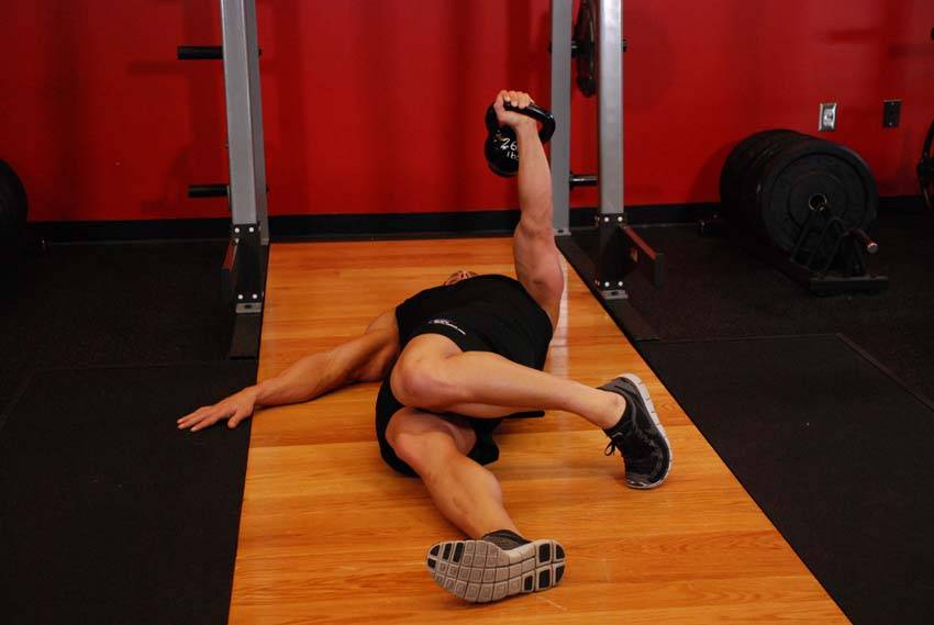 Press en el suelo a una mano con kettlebell y recorrido ampliado, final
