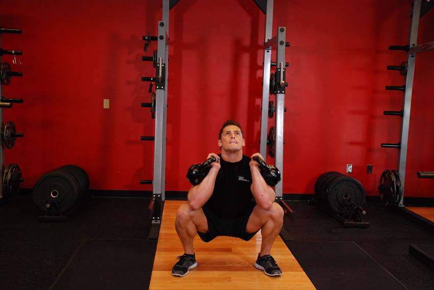 Sentadilla frontal con dos kettlebells, final