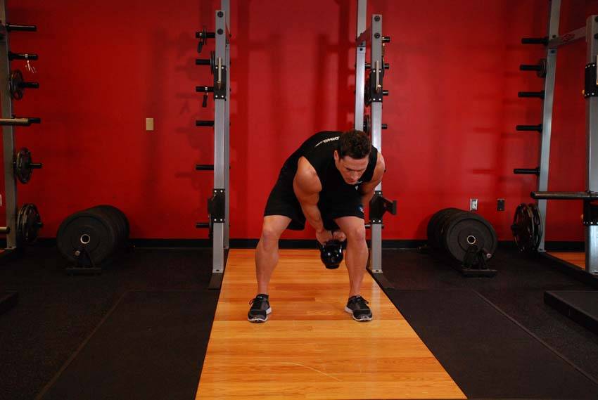 Pase de kettlebell entre las piernas, final