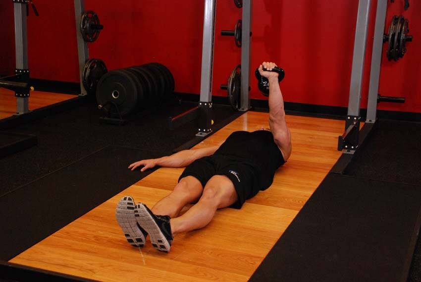 Press en el suelo a un brazo con kettlebell, final