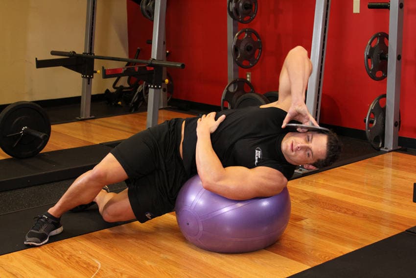 Flexión lateral sobre fitball con peso, inicio